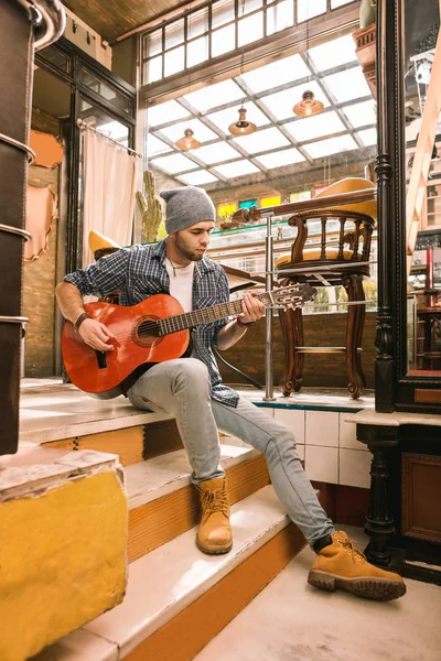 Charming male guitarist focusing on play in bar — Stock Photo, Image