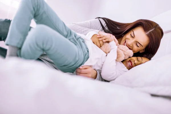 Mujer juguetona divirtiéndose con niño internacional — Foto de Stock