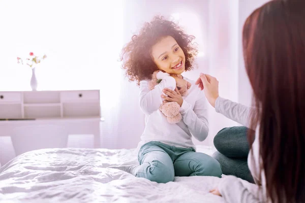 Tipo menina internacional abraçando seu lindo brinquedo — Fotografia de Stock