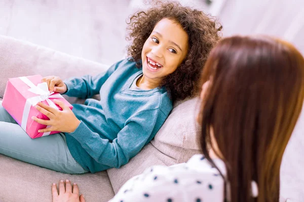 Positive delighted little girl going to open box — Stock Photo, Image