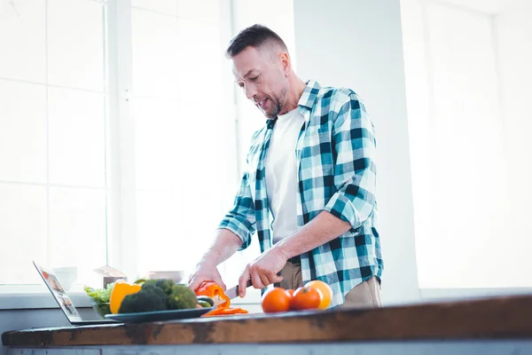 Trevlig skicklig ung man förbereder sin lunch — Stockfoto