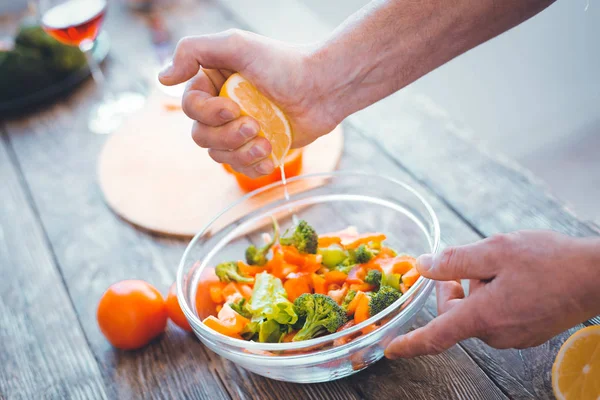 Fresh lemon juice being added to the salad — Stock Photo, Image