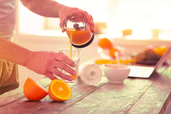 Aardige gezellige man drinken verse jus d'orange — Stockfoto