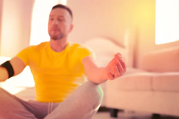 Homem calmo e espirituoso fazendo ioga no chão em casa — Fotografia de Stock