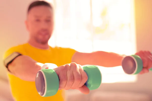 Hombre activo inspirado haciendo diferentes ejercicios en casa — Foto de Stock