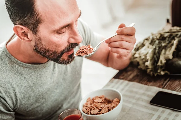 Pleasant nice handsome man holding a spoon — Stock Photo, Image