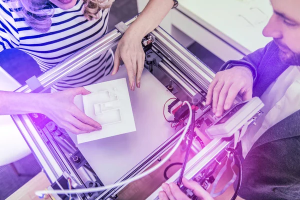 Draufsicht auf zwei moderne Geschäftsleute, die 3D-Drucker benutzen, während sie zusammen arbeiten — Stockfoto