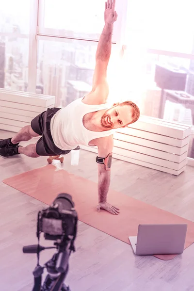 Fröhlicher Sportler beim Stretching vor der Kamera — Stockfoto