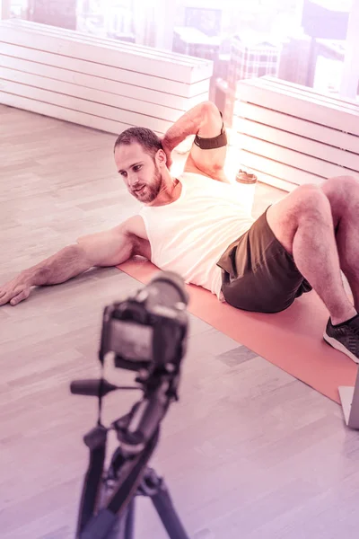 Deportista concentrado haciendo clase de entrenamiento en línea en casa —  Fotos de Stock