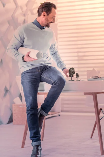 Радостный брюнетка мужчина сидит на столе — стоковое фото