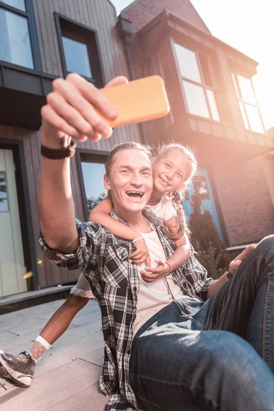 Mignon faisceau fille étreignant son père tout en faisant la photo avec lui — Photo