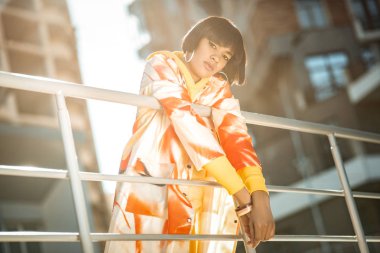 Özensiz olağanüstü kadın modeli çit yaslanmış