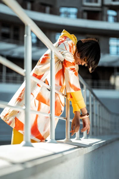 Dark-haired unusual model hanging on the railing — Stock Photo, Image