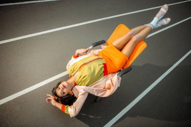 Güzel ve genç birbayan önemli ölçüde sandalyeye ters dinlenme
