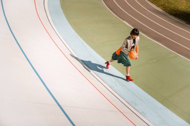 Topu ile çalışan yeşil etek giyen sportif aktif kadın