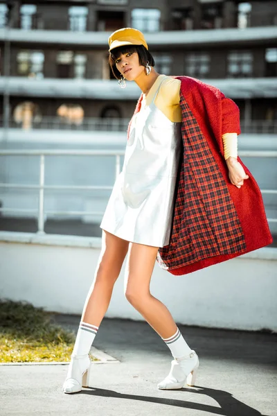 Удивительная хорошо одетая девушка, странно стоящая на бетоне — стоковое фото