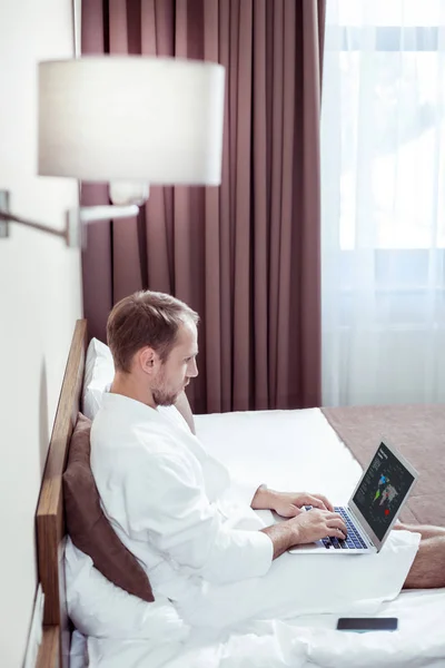 Ocupado empresário de sucesso trabalhando em seu laptop no quarto de hotel — Fotografia de Stock