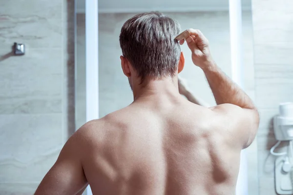 Hombre de pelo rubio con cuerpo muscular de pie delante del espejo —  Fotos de Stock