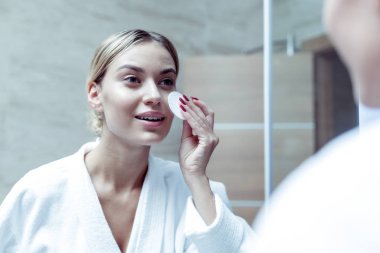 Güzel genç kadın işten sonra kozmetik remover kullanarak
