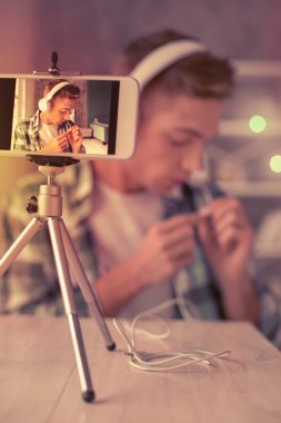 Genç çocuk beyaz kulaklık video için ayarlama