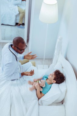 Neşeli keyifli doktor erkek çocuk için konuşuyor