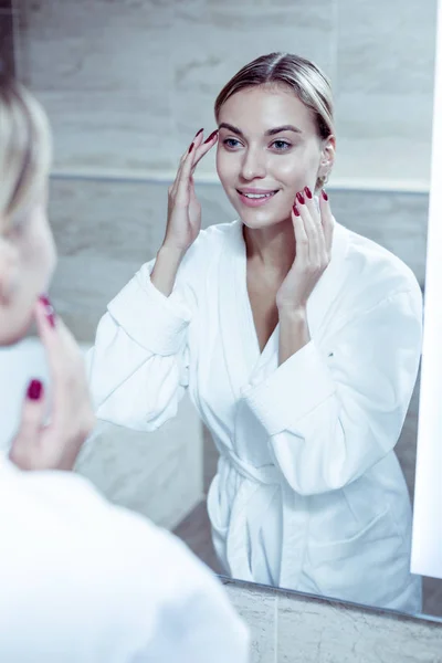 Vonzó nő visel fehér fürdőköpeny, ügyelve az arc bőre — Stock Fotó