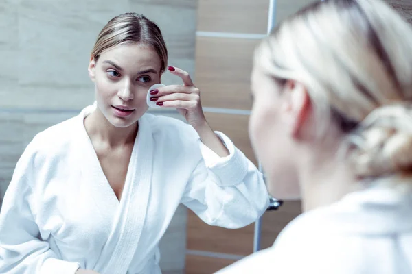 Sugárzó nő visel fehér fürdőköpeny tisztító bőre elalvás előtt — Stock Fotó