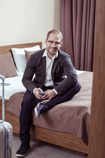 Alegre hombre de negocios sonriendo después de leer mensajes de su esposa — Foto de Stock