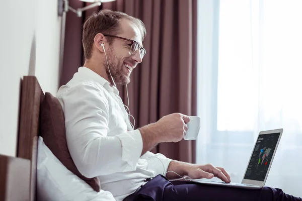 Rozpromieniony biznesmen pracę na swoim laptopie i picia kawy — Zdjęcie stockowe
