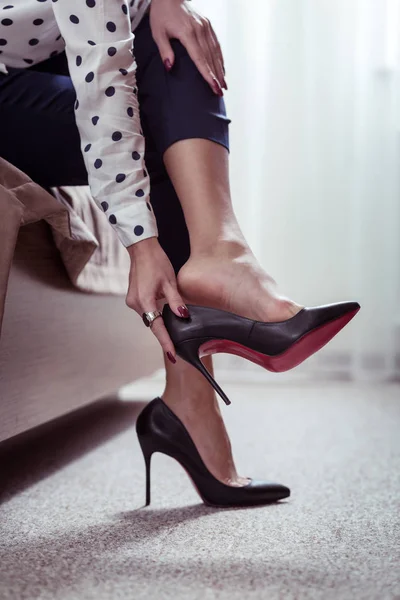 Busy businesswoman taking off her high-heeled shoes after long hard day — Stock Photo, Image