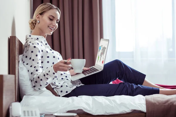 Eleganta kvinnan shilling med kaffe på hotel säng efter möten — Stockfoto