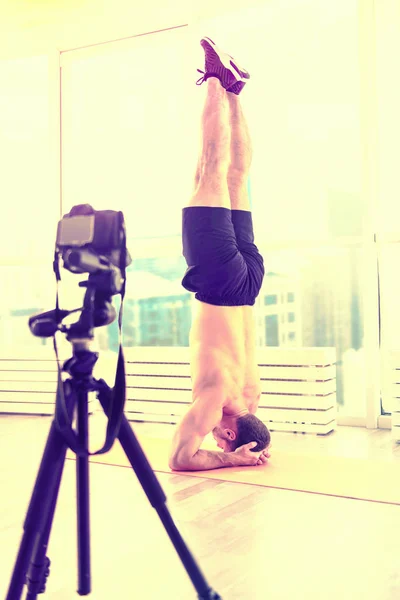 Deportivo hombre guapo haciendo ejercicio en el suelo en una habitación —  Fotos de Stock