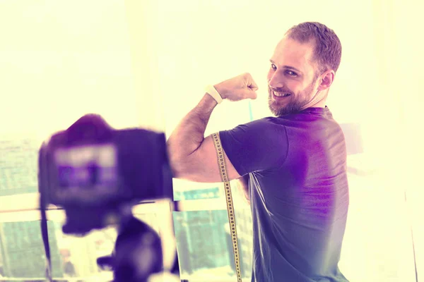 Sportowy silnego człowieka, pokazuje jego mięśnie przed kamerą — Zdjęcie stockowe