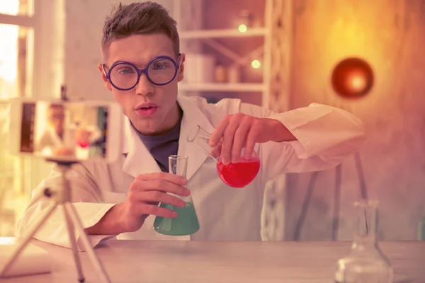 Jeune homme intéressé faire de la chimie nouvelle expérience — Photo