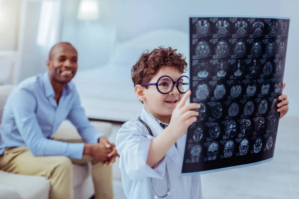 Positieve mooie jongen, kijkend naar de afbeelding van X ray — Stockfoto