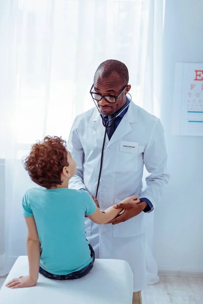 Smart nice man standing in front of his patient — Stock Photo, Image