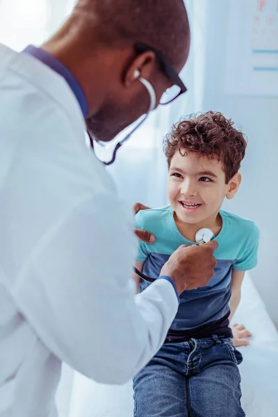 Leuke vrolijke jongen lacht om zijn arts — Stockfoto