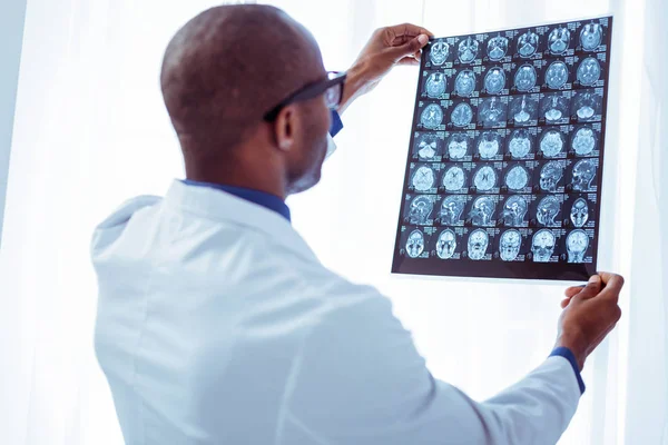 Розумний приємний лікар, який перевіряє рентгенівське зображення — стокове фото