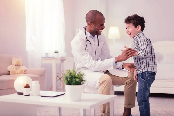 Feliz chico positivo de pie cerca de su médico — Foto de Stock