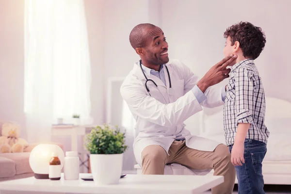 Glada Afro amerikansk läkare tittar på hans patient — Stockfoto