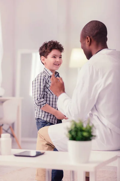 Glücklicher positiver Junge im Gespräch mit seinem Arzt — Stockfoto