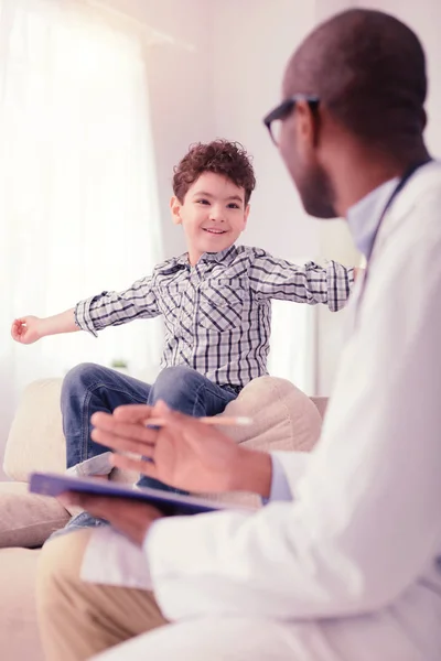 Pozytywne cute chłopiec mówi do lekarza — Zdjęcie stockowe
