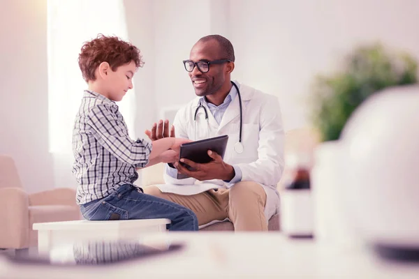 Хороший радісний хлопчик розмовляє зі своїм лікарем — стокове фото