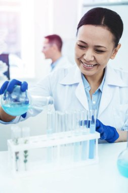 Test tüpleri sıvı dökme mutlu güzel kadın