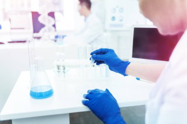 Mavi kauçuk eldiven giymiş profesyonel kadın bilim adamı