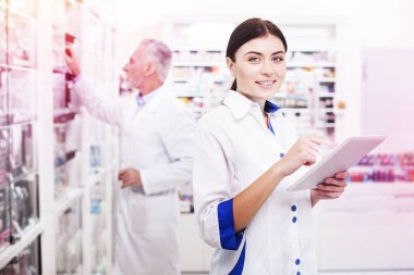 Gülümseyen bir tablet için işaret eden profesyonel kadın