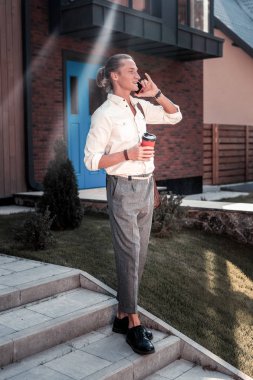 Şık yakışıklı onun evden çıkarken süslü siyah ayakkabı giyiyor