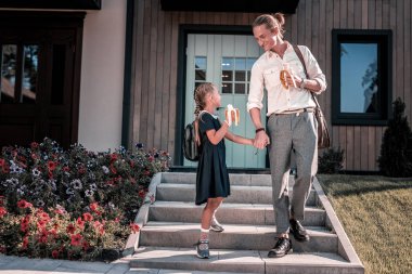 Okul üniforması giyen kızı ve sırt çantası için baba konuşuyor