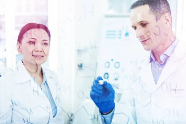 Positive cheerful man writing a chemical formula — Stock Photo, Image