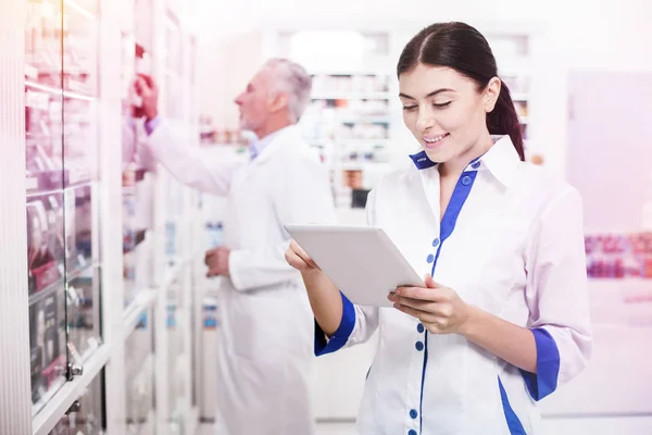 Mujer joven ayudando a su colega en una farmacia —  Fotos de Stock